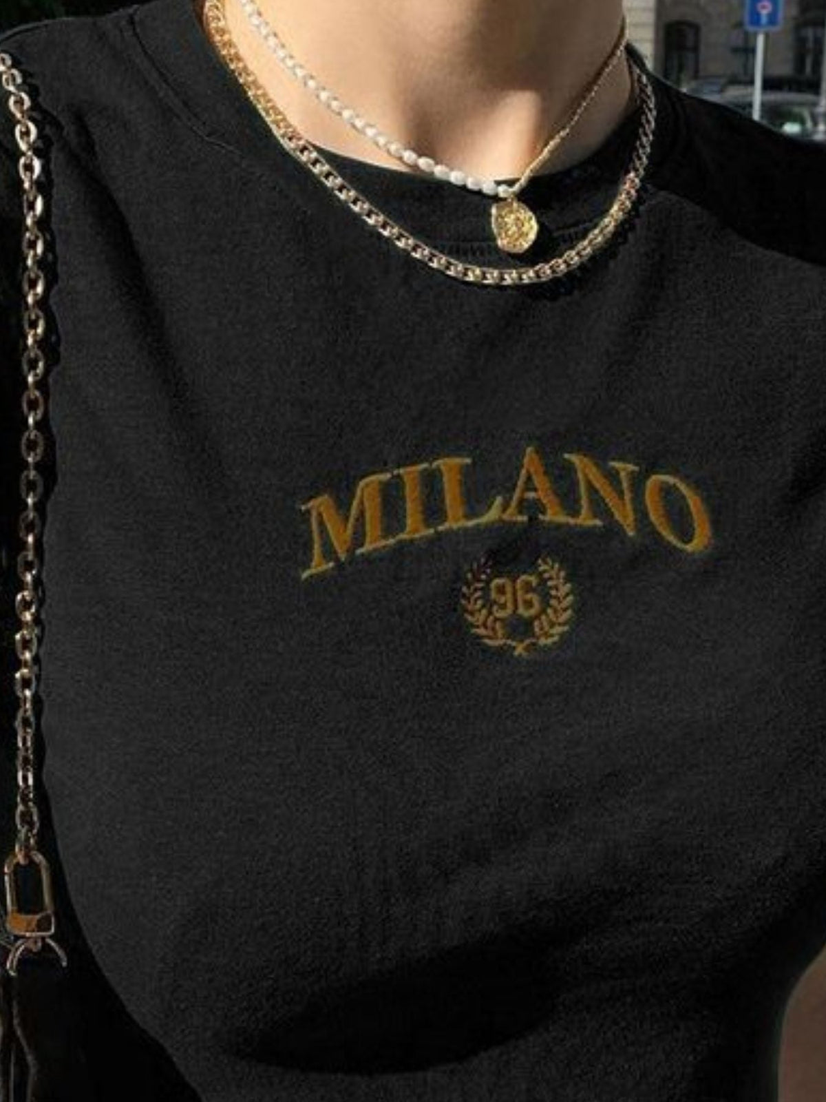A Classy Chic Boutique black crop top featuring gold embroidered Milano 96 graphic with a laurel wreath detail.