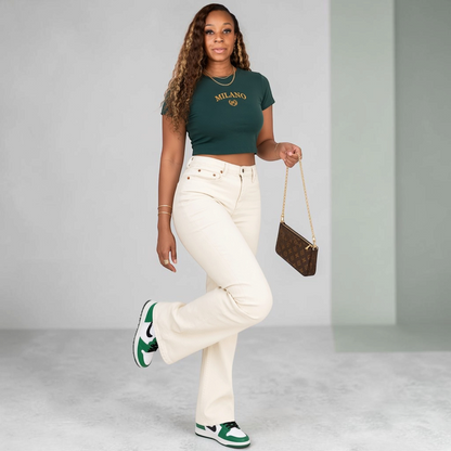 A Classy Chic Boutique forest green crop top with Milano embroidery, worn with cream jeans and green sneakers.